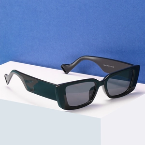 Modern rimless metal sunglasses with black frames and wide stepped temples on white podium