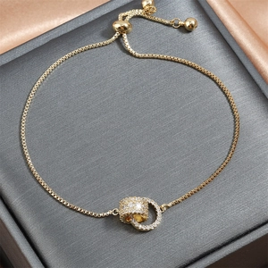 Bracciale dorato regolabile con doppi anelli intrecciati e zirconi cubici incastonati