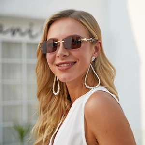 Close-up of rimless square sunglasses with wood grain temples on a female model