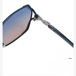 Detailed view of silver metal hinges with textured engraving on black sunglasses