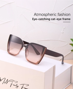 Detail of cat eye sunglasses with brown gradient lenses and gold metallic accents