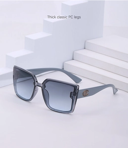 Détail de lunettes de soleil carrées avec verres dégradés gris et logo CG sur les branches