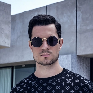 Close-up of retro round gold metal sunglasses on a model with grey tinted lenses
