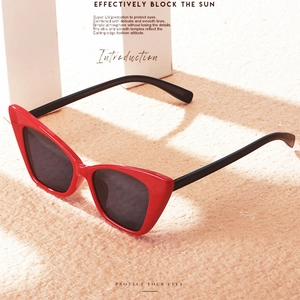 Fashionable red cat eye sunglasses for women with UV protection on sand background