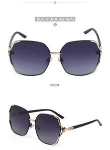 Detail of oversized polarized sunglasses with golden metal frames and leaf temple accents