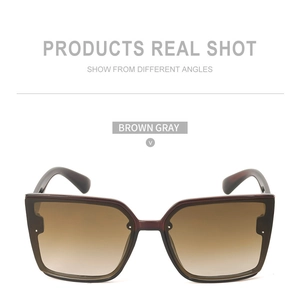 Vue de face de grandes lunettes de soleil carrées avec verres dégradés marron et rivets
