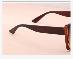 Side view detail of translucent brown oversized cat-eye sunglasses with gradient lenses