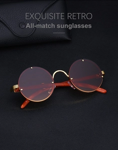Detailed close-up of retro round sunglasses with gold metal frame and wood grain temples