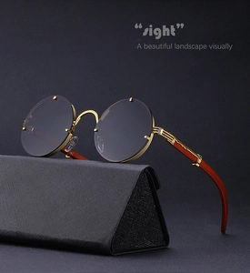 Detail of round sunglasses featuring gold metal hinges and brown wood grain temples