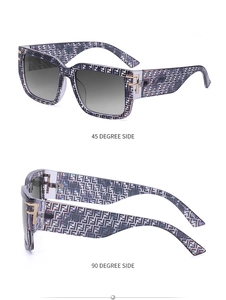 Detail view of square sunglasses featuring logo-patterned frames and gradient grey lenses