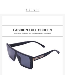 Close-up of black oversized sunglasses with fashion golden chain detail on temples