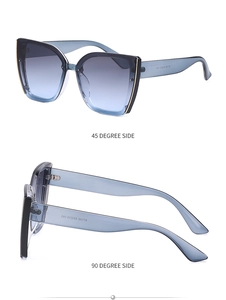 Detail view of cat eye sunglasses with gray-blue gradient lenses and gold metal accents