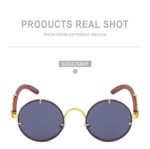 Detail view of round vintage sunglasses with gold frame and red-brown wood grain temples