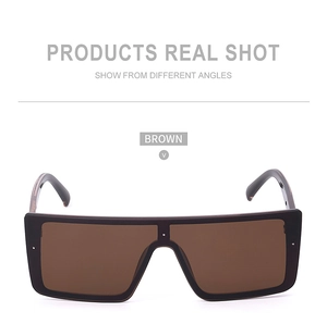 Detail view of large rectangle sunglasses with brown lenses and thick black frames