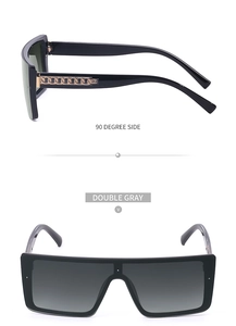 Close-up of oversized black sunglasses with unique gold chain detail on the side temples