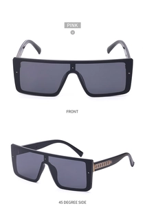 Detailed view of oversized black square sunglasses with gold chain accents on temples