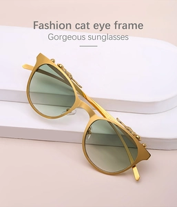 Dettaglio di occhiali da sole cat-eye dorati con accenti di leopardo 3D e lenti sfumate