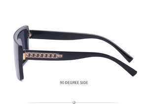 90 degree side view of oversized square sunglasses with gold metal chain on temple