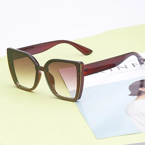 Oversized cat-eye sunglasses with burgundy translucent frames and brown gradient lenses
