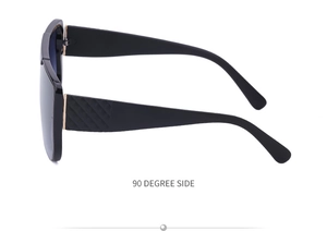 Detailed side view of oversized black sunglasses with quilted texture and gold hinges