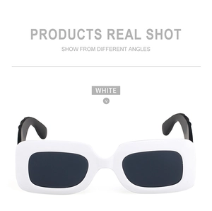 Detail view of stylish white rectangular frames with black temples and dark lenses