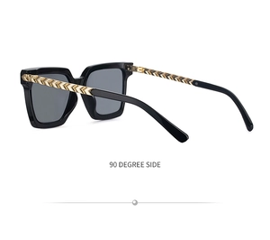 Side view of square sunglasses with golden textured temples and V-shaped metal hardware