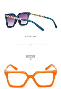 Detail of square sunglasses with blue and orange frames and golden geometric metal temples