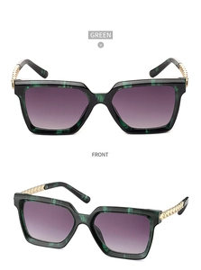 Macro view of green marbled sunglasses frames with detailed gold metal braided temples