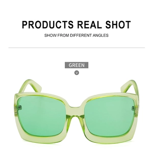 Detailaufnahme der grünen Oversize-Quadrat-Sonnenbrille mit transparentem Rahmen und Glas