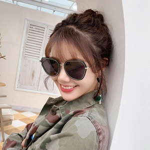 Fashionable oversized square sunglasses with dark grey lenses and metal temples on model
