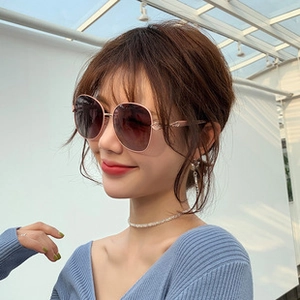 Detail of pink oversized sunglasses with gradient lenses and decorative metal temples