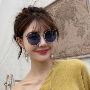 Detail of silver round frame sunglasses with dark grey lenses on female model