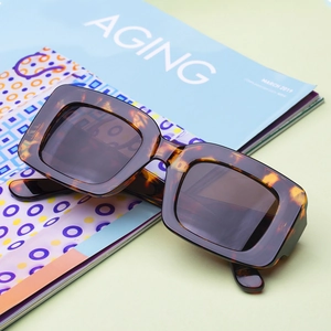 Retro rectangular tortoiseshell sunglasses for women with dark lenses on lifestyle background