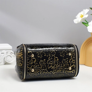 Vintage black glossy tote bag with golden floral relief and protective metal bottom studs
