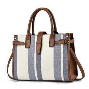 Minimalist blue striped canvas tote bag with contrast brown leather trim and shoulder strap