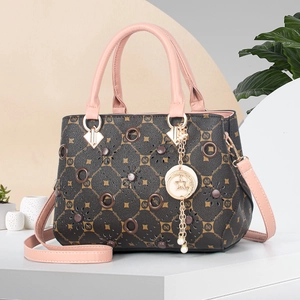 Close-up of contrast lattice handbag with gold moon pendant and pink handle details
