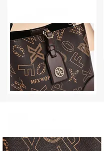 Détail d'un sac seau marron foncé en similicuir grainé avec pendentif logo métallique
