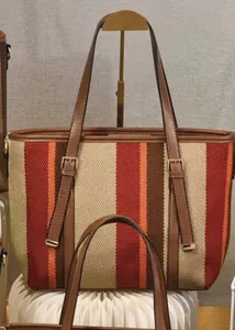 Detail of color-block striped tote bag with leather straps and metal buckle accents