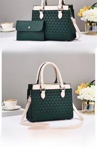 Detail of dark green tote and wallet set with geometric embossed patterns and cream straps