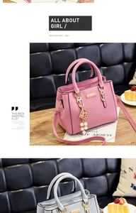 Detail of light pink lychee texture leather bag with gold hardware and pearl charm