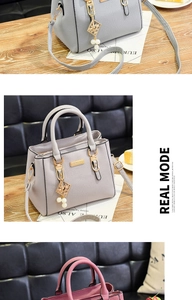 Detail of light gray textured handbag with gold geometric charm and pearl pendant