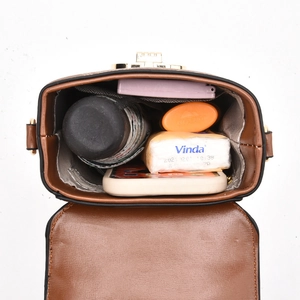 Vintage brown monogram crossbody bag showing interior capacity with daily essentials