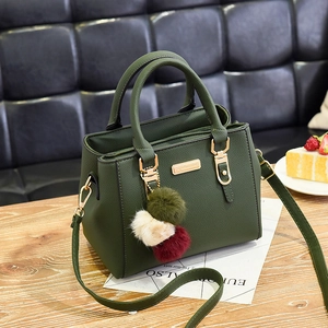 Dark green pebbled leather handbag with tri-color fur pompom and gold hardware