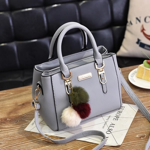 Chic grey litchi leather handbag with dual handles and colorful pom-pom charm