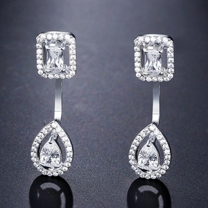 Macro detail of silver-tone teardrop and square earrings with micro-pave cubic zirconia