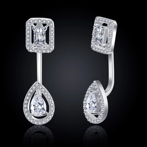 Macro view of silver teardrop and emerald-cut cubic zirconia earrings with pavé halo