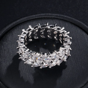 Détail d'une bague éternité en zircons taille marquise sur un coussin à bijoux noir