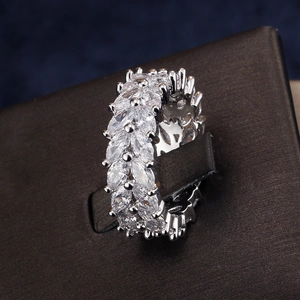 Gros plan d'une bague éternité sertie de zircons marquise sur un écrin texturé sombre