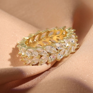 Bague éternité dorée avec zircons marquise sur fond en satin élégant pour femmes