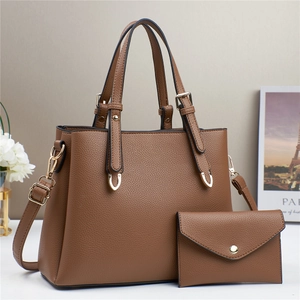 Detailed close-up of brown litchi pattern leather tote bag with matching envelope pouch